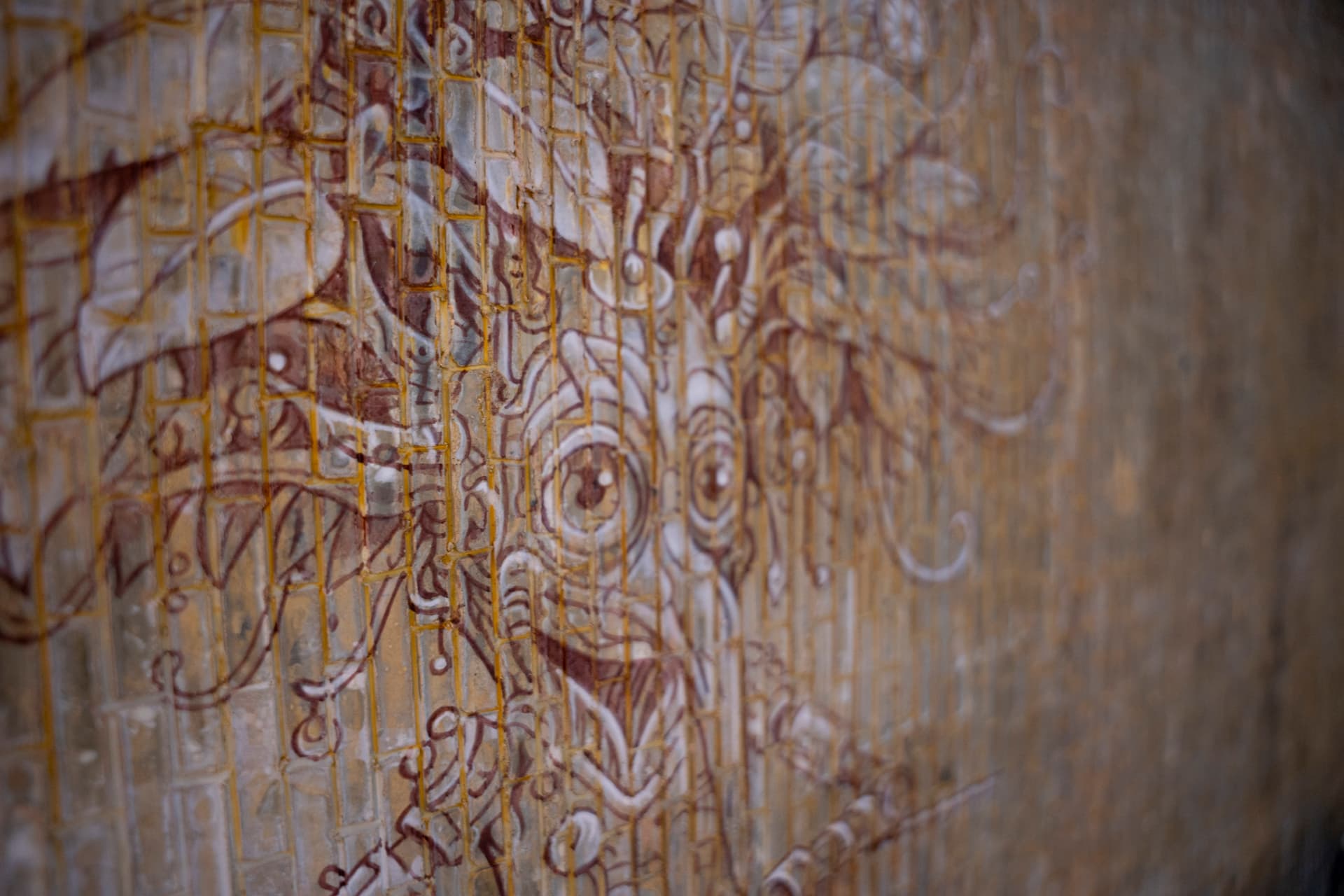 Close detail of a drawn figure over a brick surface